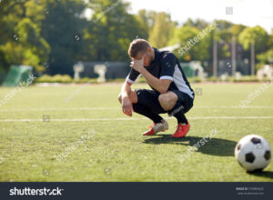 stock-photo-sport-football-fail-loss-and-people-sad-soccer-player-with-ball-on-field-570884620